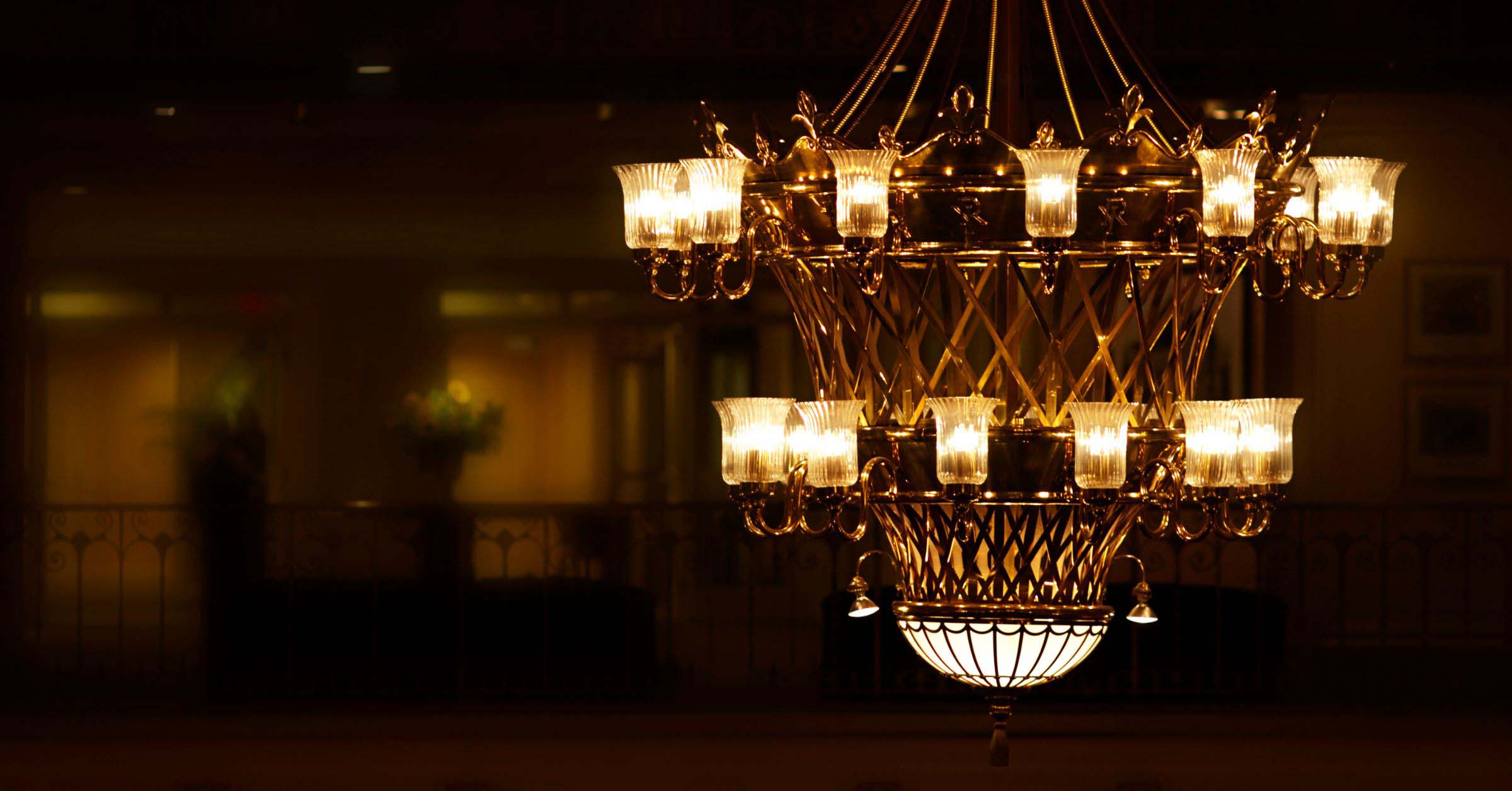 [image: Art Deco chandelier lit up and hanging from the ceiling]