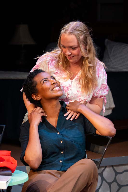 [image: Young love: a smiling Black woman with a smiling white woman behind her, hands on her shoulders]